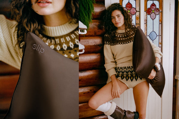A split-screen lifestyle image showing a woman wearing a beige knit sweater with a brown pattern, holding a chocolate brown silk pillowcase. The left panel is a close-up of the pillow with the brand name 'slip' embroidered, and the right panel shows the woman standing in front of a stained-glass window.