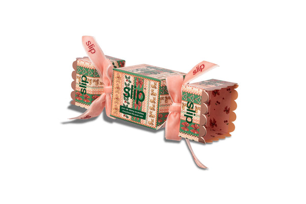 Slip Scrunchie cracker packaging with a pink ribbon, each printed with the word 'slip' and a festive pattern, on a plain white background.