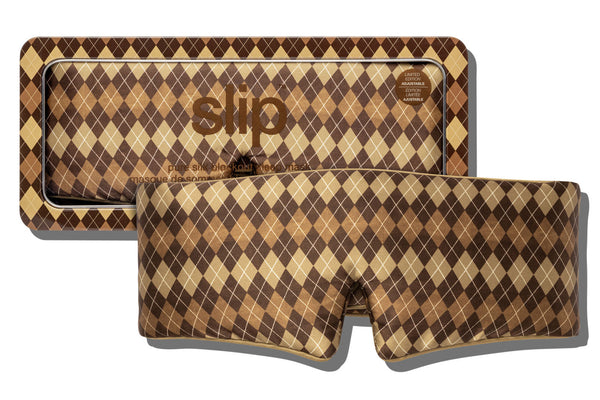 A slip blockout sleep mask with a brown, tan, and beige argyle pattern, shown in front of its matching patterned packaging box on a white background.