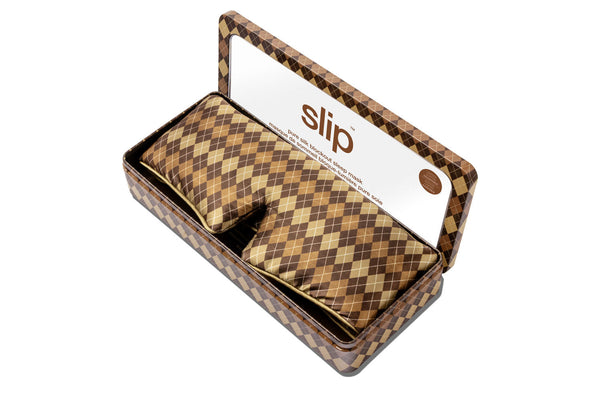 Slip Blockout Sleep Mask in a brown and beige argyle pattern, presented inside an open matching patterned tin box.