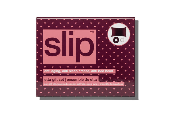 Slip brand 'etta gift set' packaging box, featuring a dark burgundy background patterned with small pink hearts, a large pink central panel with the brand name 'slip' in dark burgundy, and a white circular inset showing the included bedding items.
