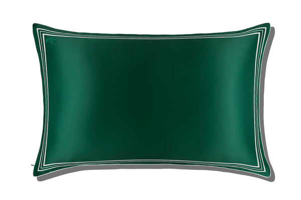 Green silk pillowcase with white decorative trim and piping on a white background